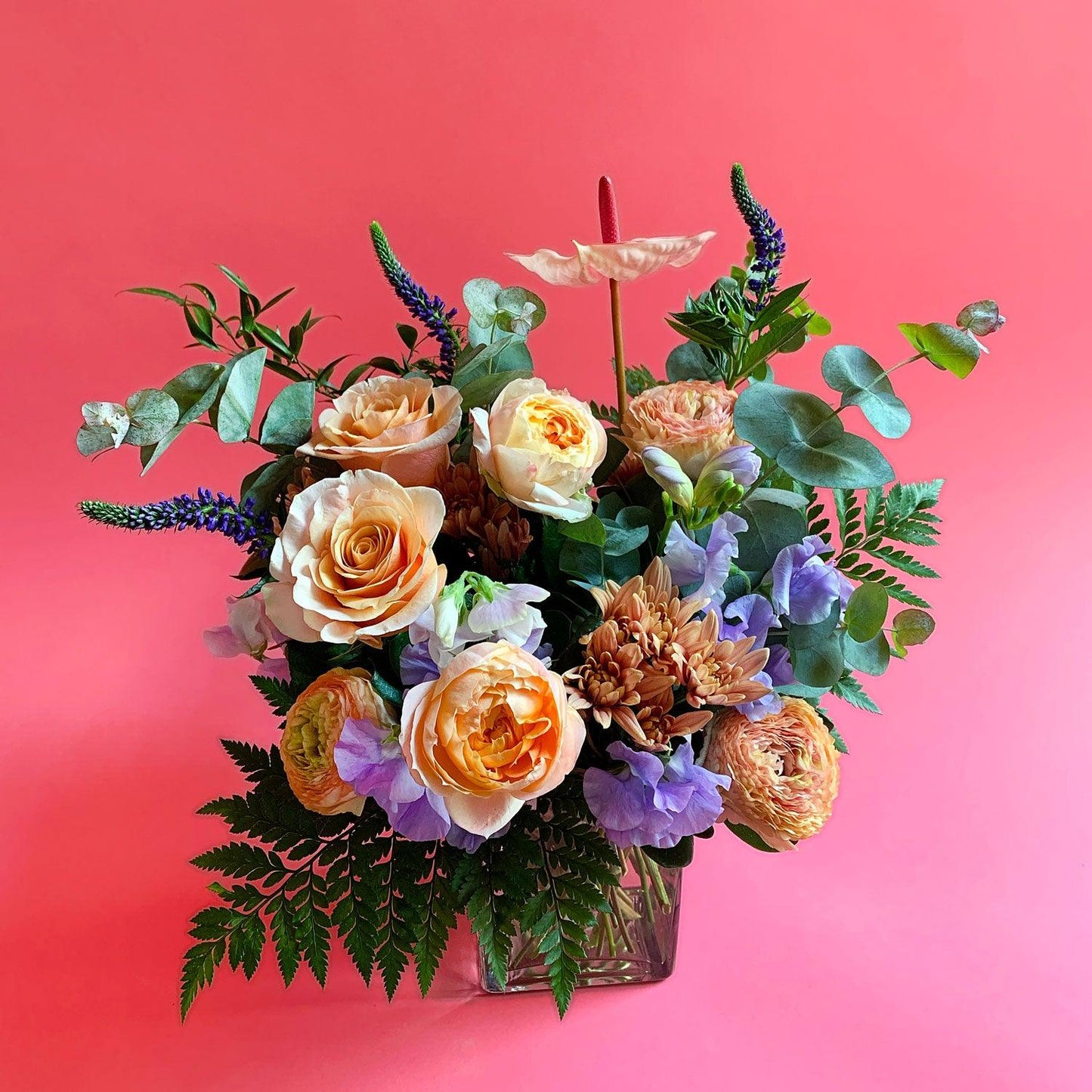 Image of a bouquet with sweet peach and apricot tones, deepening to lavender and blue, with a touch of foliage for freshness. Order online for same-day flower delivery from Toronto's best florist, available near you.