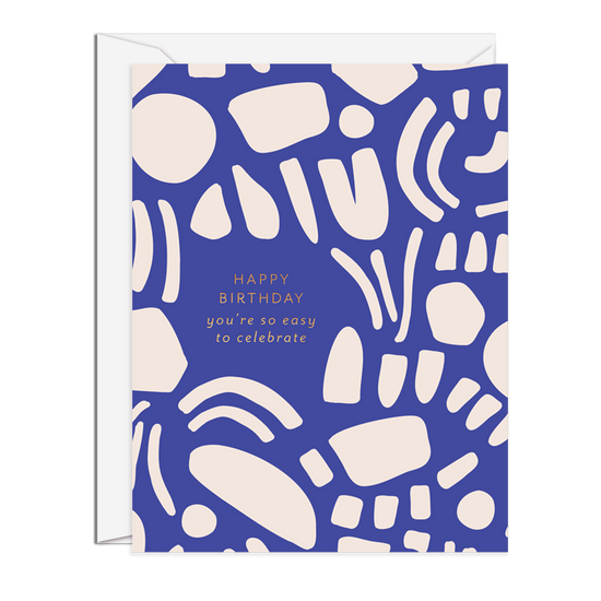 A birthday greeting card with a blue background featuring abstract white shapes and a birthday message in white text: ‘HAPPY BIRTHDAY you’re so easy to celebrate’.Order online for event items from the best florist in Toronto near you.