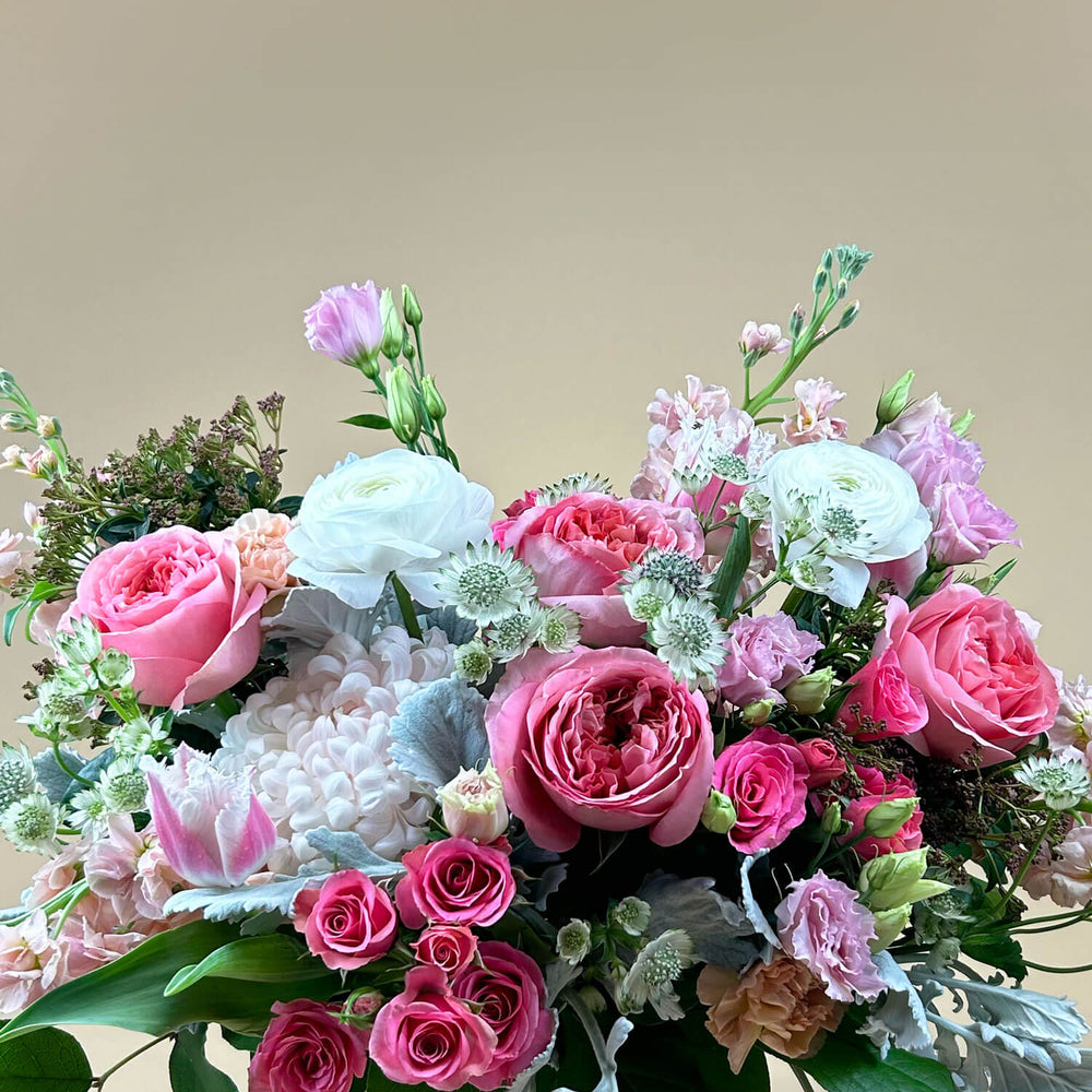 
                      
                        Close-up Image of a bouquet featuring airy pastel pink and delicate cream flowers, including a mix of white and pink roses, blush ranunculus, lisianthus, and carnations. Celebrate gender non-binary expression with this sweet palette. Order online for same-day flower delivery from Toronto's best florist, available near you.
                      
                    