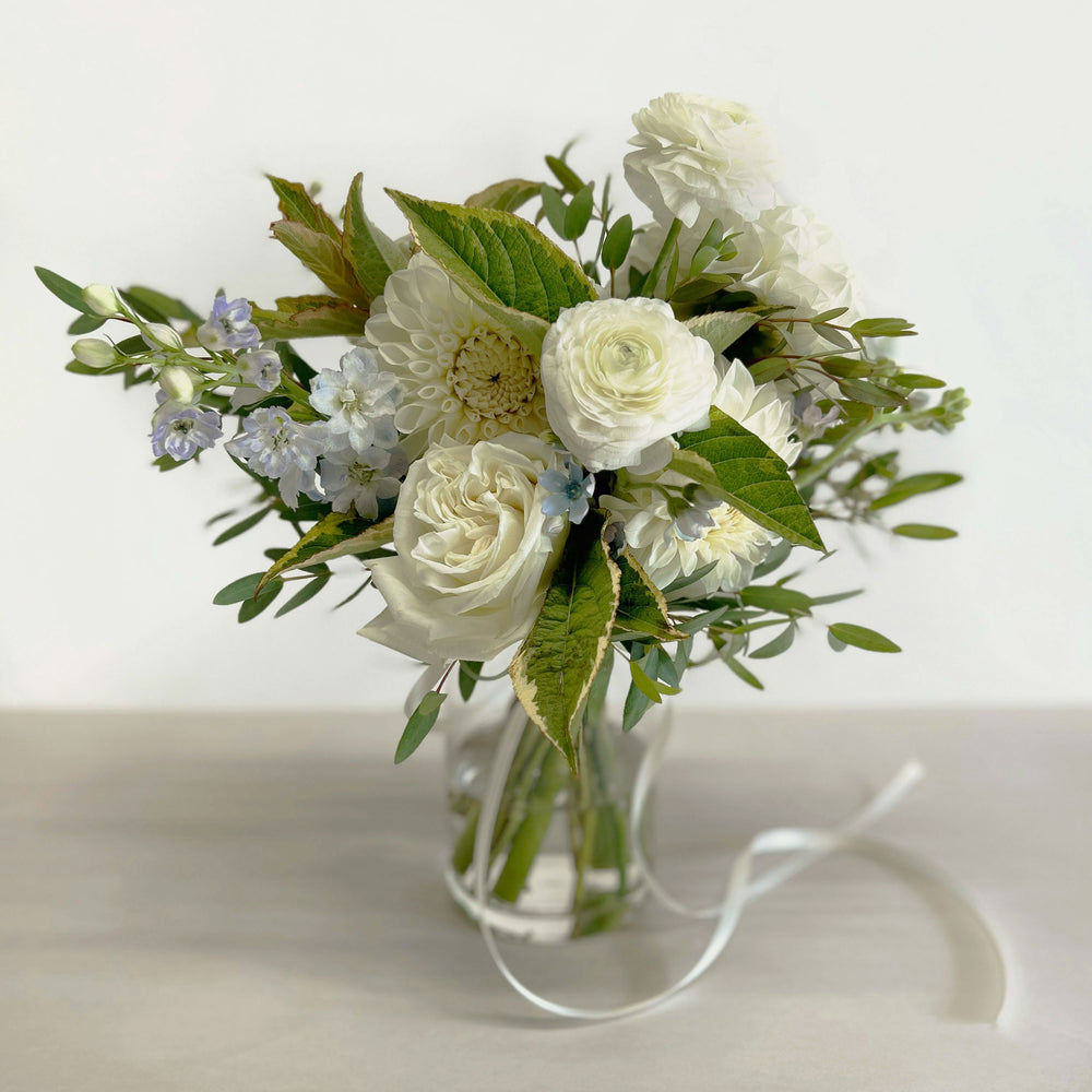 
                      
                        Full shot, Soft whites, peaches, and light blue flowers. Attendant bouquet, bridesmaid bouquet, posy-style bouquets for bridesmaids. They emphasize blooms over greenery, are hand-tied & finished with a ribbon of your choice, and come in a vase. From the best wedding florist in Toronto Quince Flowers.
                      
                    