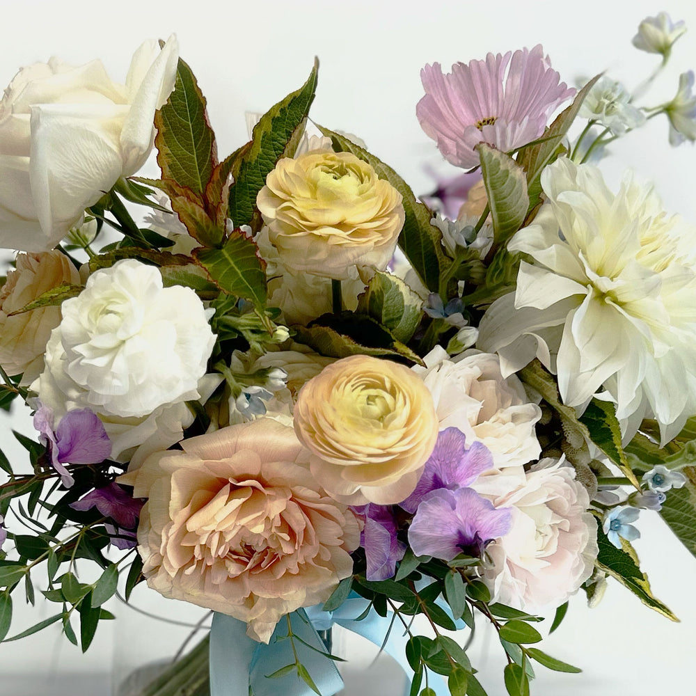 Closeup, Soft white and pink flowers. Bridal bouquet – Our bouquets marry creative vision and nature. We work with luxurious flower varieties including garden roses, dahlias, and peonies in season. They emphasize blooms over greenery, are hand-tied & finished with a ribbon of your choice, and come in a vase. From the best wedding florist in Toronto Quince Flowers.