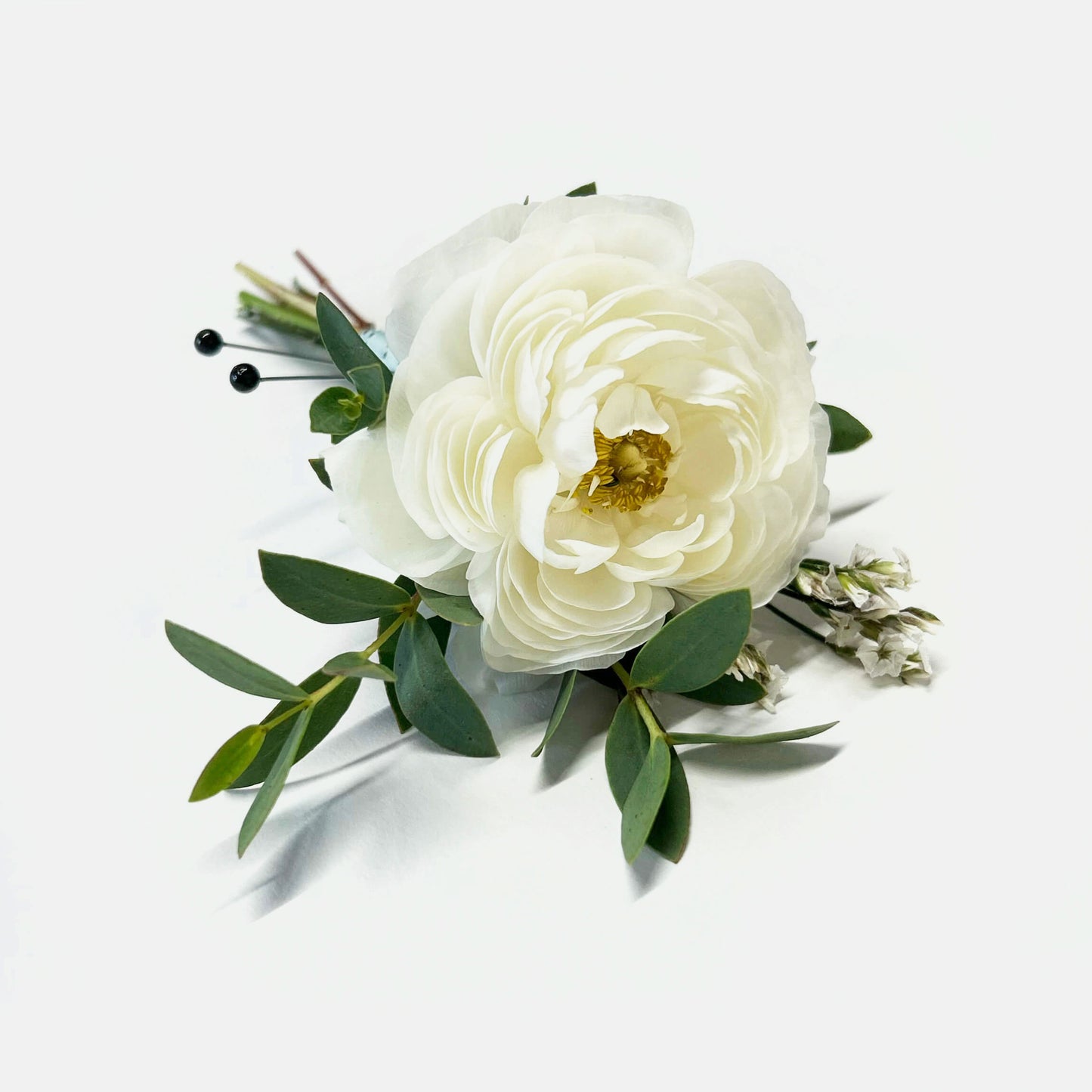 White flower Boutonniere – Worn on the lapel of a tuxedo or suit jacket, boutonnieres or “buttonhole” flowers, typically use a single blossom, foliage, and textured elements, finished with ribbon. From the best wedding florist in Toronto Quince Flowers.