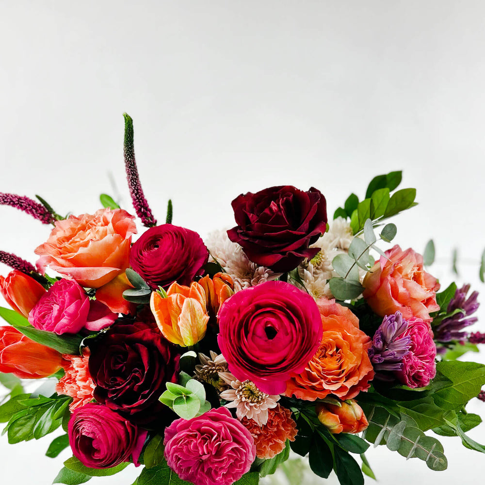 
                      
                        Close-up Image of a daring bouquet featuring spring flowers and roses, including hyacinth, tulips, hot pink ranunculus, veronica, lisianthus, and blush hydrangea. Order online for same-day flower delivery from Toronto's best florist, available near you.
                      
                    