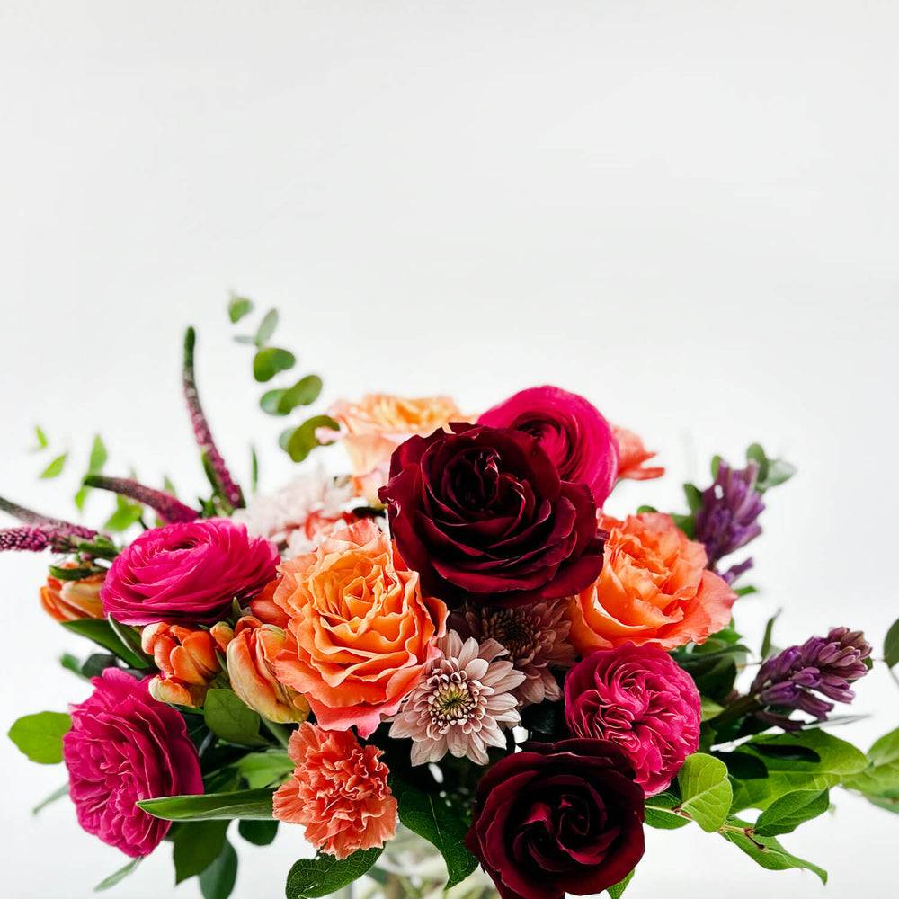 
                      
                        Close-up Image of a daring bouquet featuring spring flowers and roses, including hyacinth, tulips, hot pink ranunculus, veronica, lisianthus, and blush hydrangea. Order online for same-day flower delivery from Toronto's best florist, available near you.
                      
                    