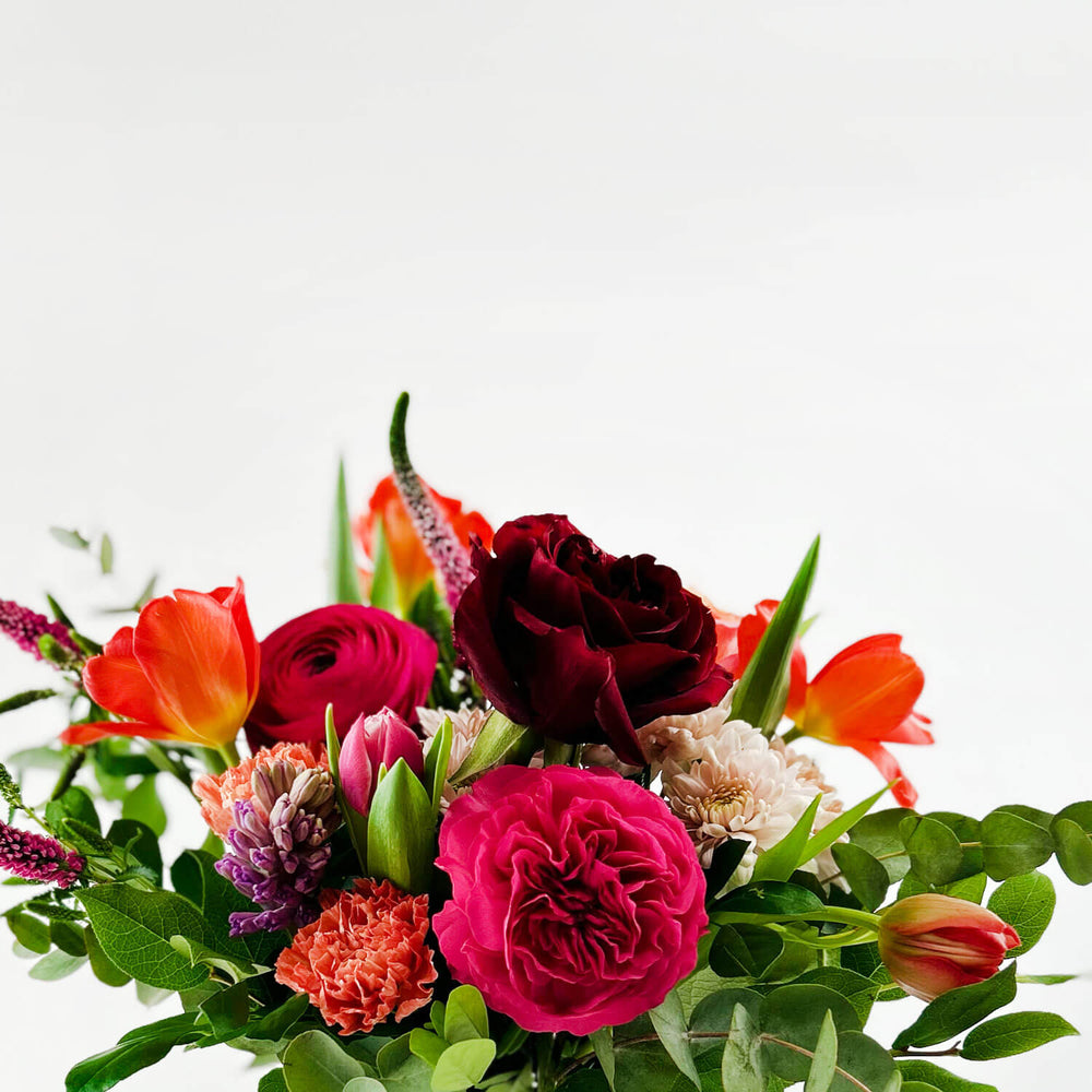 
                      
                        Close-up Image of a daring bouquet featuring spring flowers and roses, including hyacinth, tulips, hot pink ranunculus, veronica, lisianthus, and blush hydrangea. Order online for same-day flower delivery from Toronto's best florist, available near you.
                      
                    