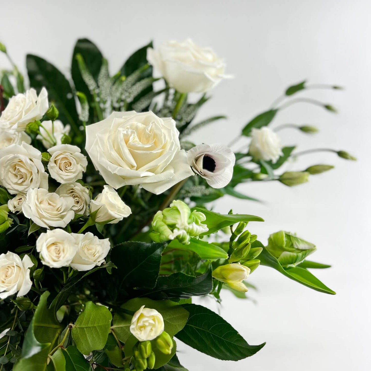 Close-up Image of a romantic bouquet featuring cream and white flowers, including garden roses, parrot tulips, freesia, and ranunculus. Order online for same-day flower delivery from Toronto's best florist, available near you.