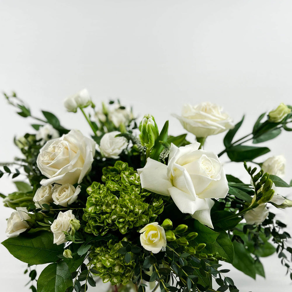 
                      
                        Close-up Image of a romantic bouquet featuring cream and white flowers, including garden roses, parrot tulips, freesia, and ranunculus. Order online for same-day flower delivery from Toronto's best florist, available near you.
                      
                    