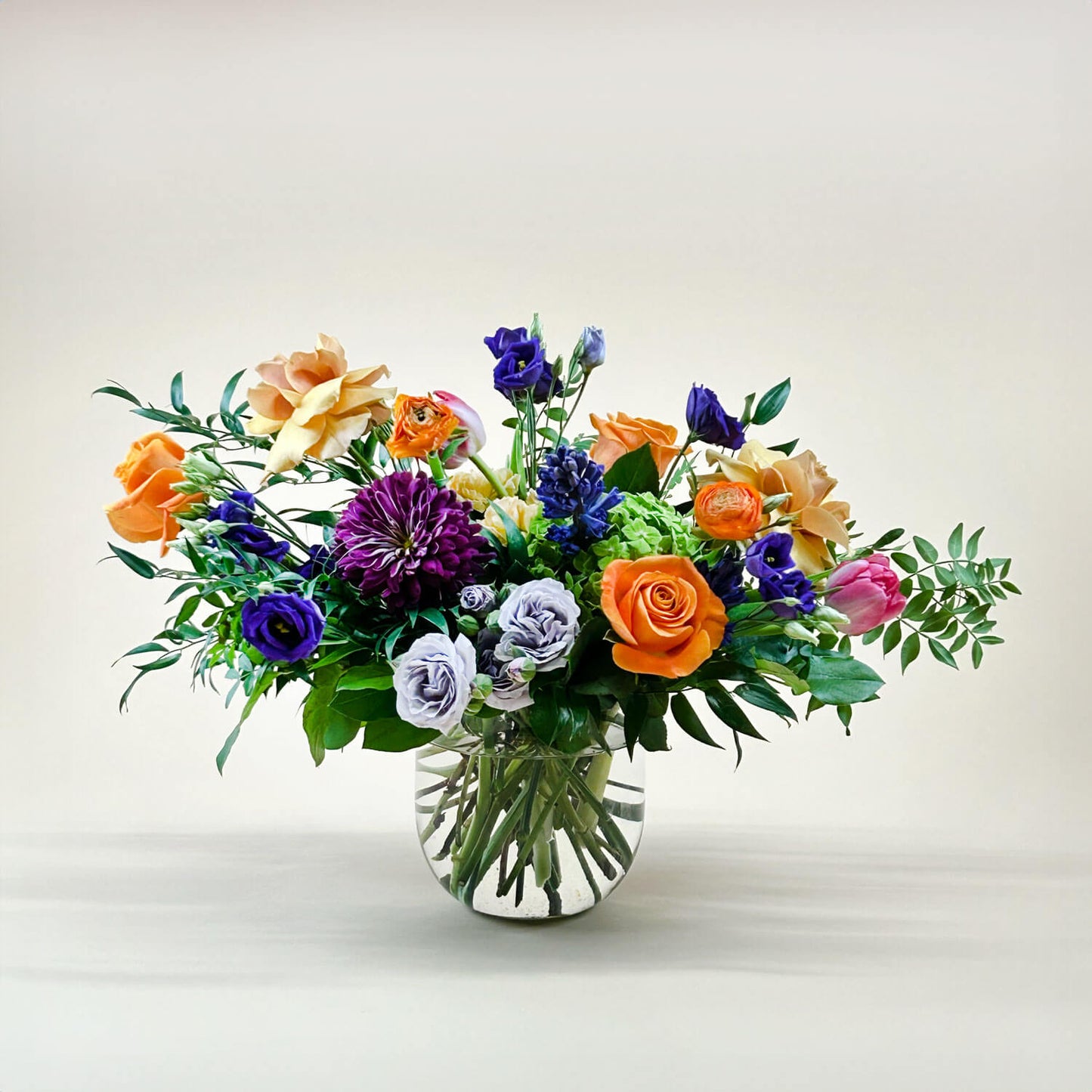 Image of a dynamic bouquet featuring yellow and lavender hues transitioning into deeper purple tones, with accents of citrus orange for vibrancy. A thoughtful and romantic combination. Order online for same-day flower delivery from Toronto's best florist, available near you.
