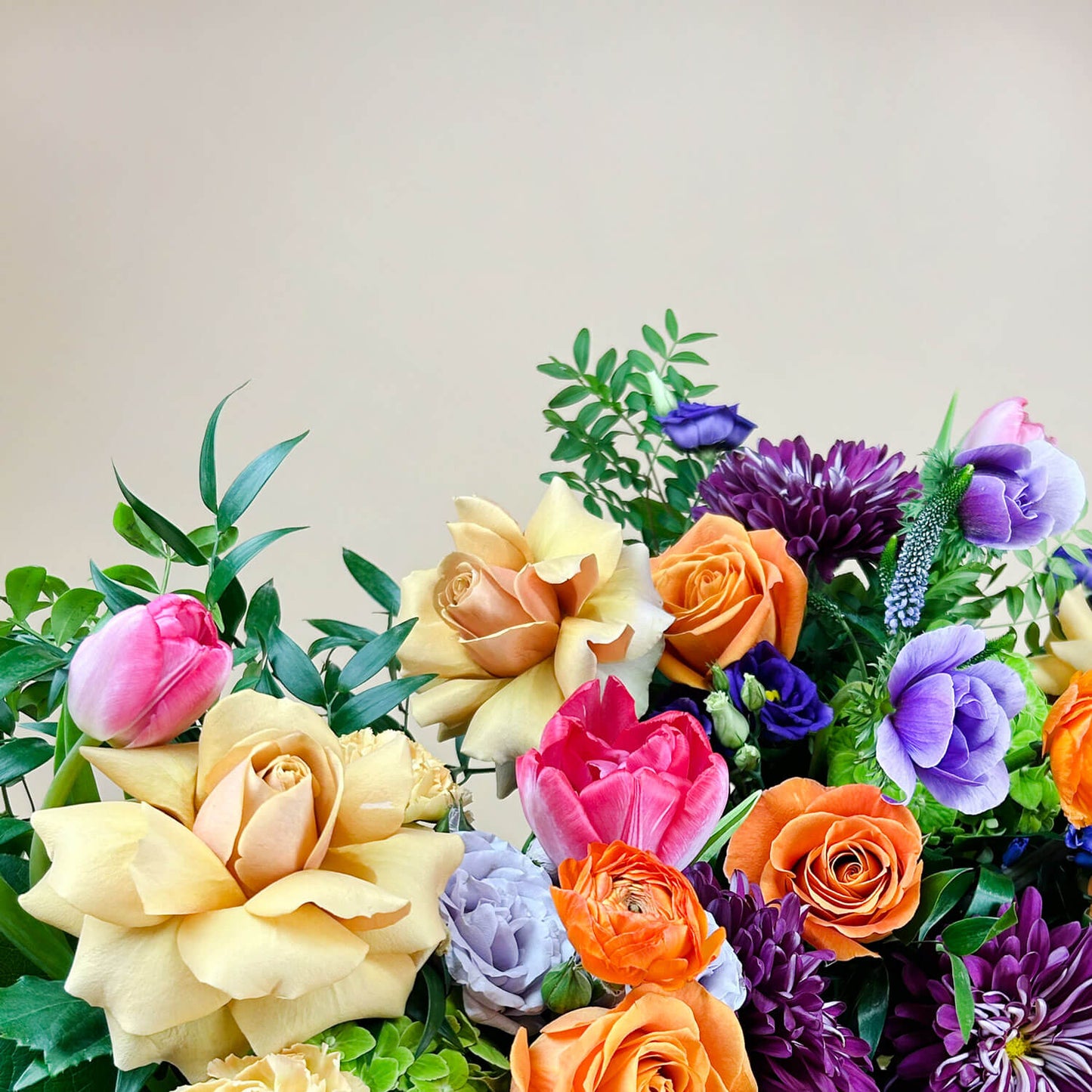 Close-up image of a dynamic bouquet featuring yellow and lavender hues transitioning into deeper purple tones, with accents of citrus orange for vibrancy. A thoughtful and romantic combination. Order online for same-day flower delivery from Toronto's best florist, available near you.