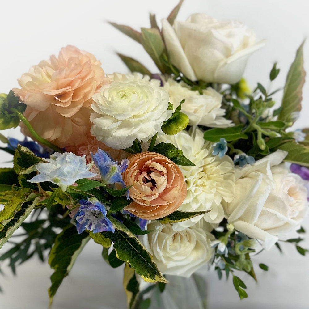 
                      
                        close up, Soft whites, peaches, and light blue flowers. Attendant bouquet, bridesmaid bouquet, posy-style bouquets for bridesmaids. They emphasize blooms over greenery, are hand-tied & finished with a ribbon of your choice, and come in a vase. From the best wedding florist in Toronto Quince Flowers.
                      
                    