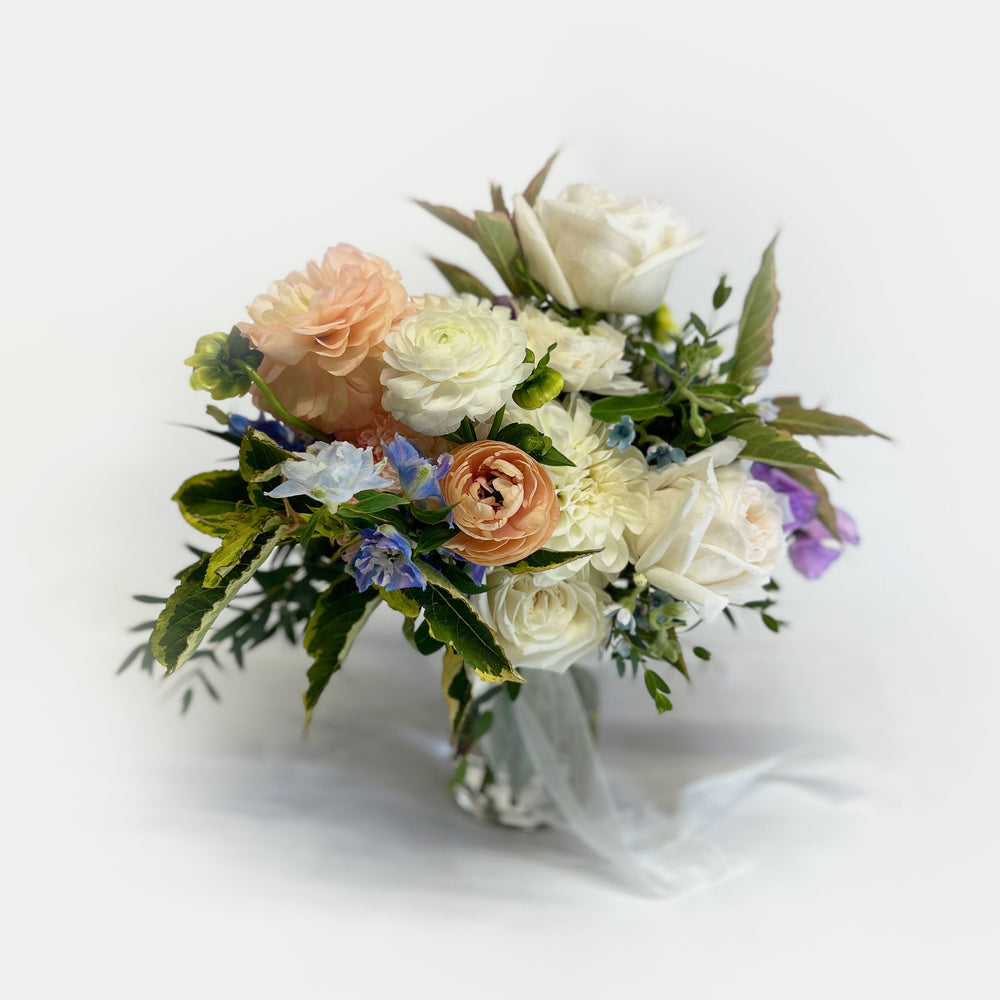 
                      
                        Full shot, Soft whites, peaches, and light blue flowers. Attendant bouquet, bridesmaid bouquet, posy-style bouquets for bridesmaids. They emphasize blooms over greenery, are hand-tied & finished with a ribbon of your choice, and come in a vase. From the best wedding florist in Toronto Quince Flowers.
                      
                    