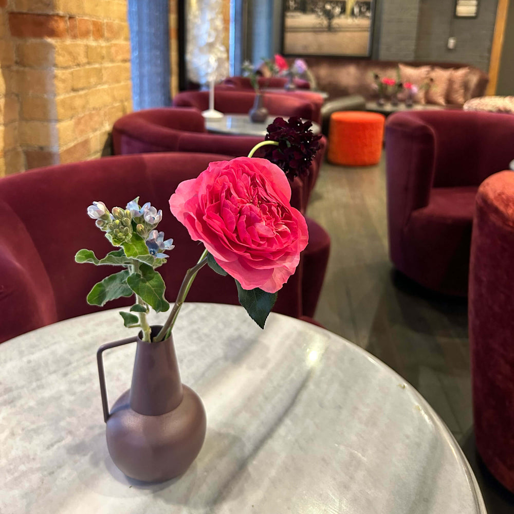 Bright pink, greenery and soft blue flowers. Workplace mini small tabletop arrangement – for a workplace countertop, workplace weeklies for B2B flowers in Toronto, Quince Flowers – Toronto’s best B2B florist, available near you.