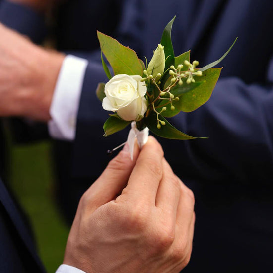 Elegant boutonniere made of white flowers and green leaves, Order online for wedding & event flowers from the best florist in Toronto near you.