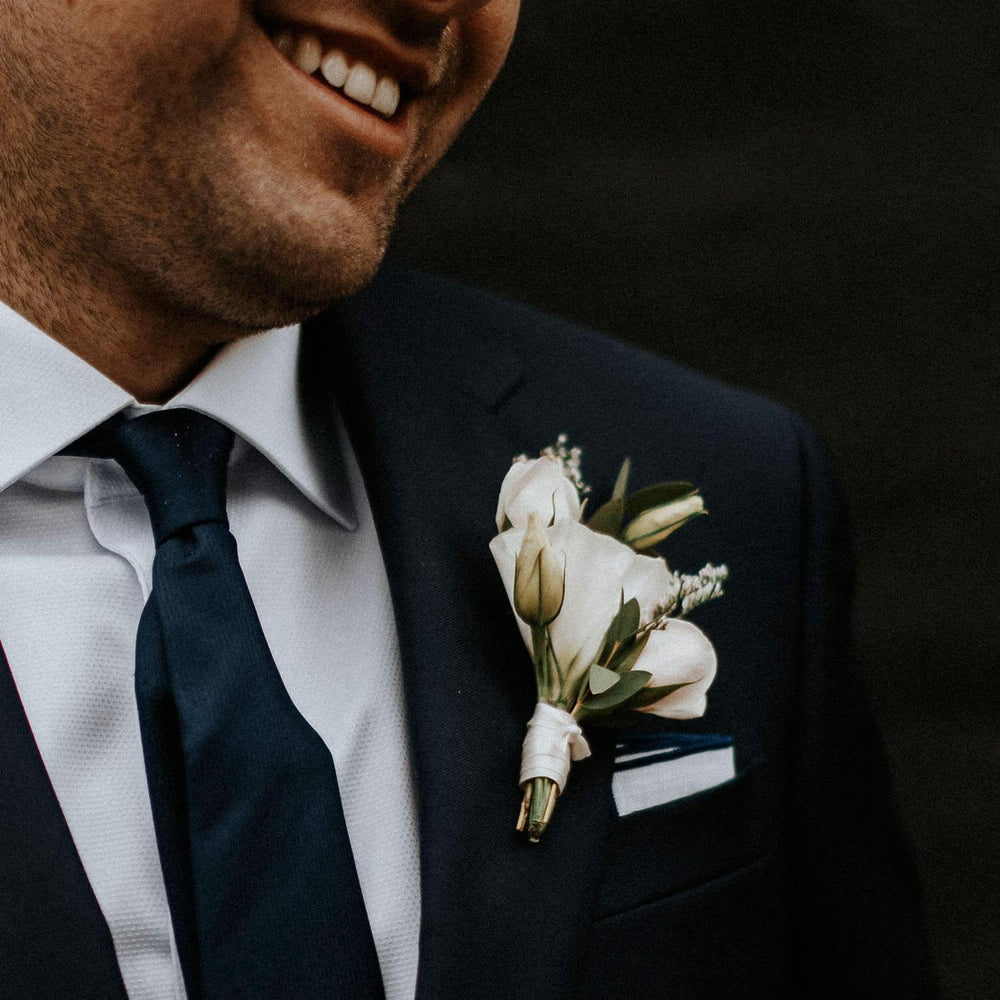 
                      
                        Elegant boutonniere made of white flowers and green leaves, From the best wedding florist in Toronto Quince Flowers.
                      
                    