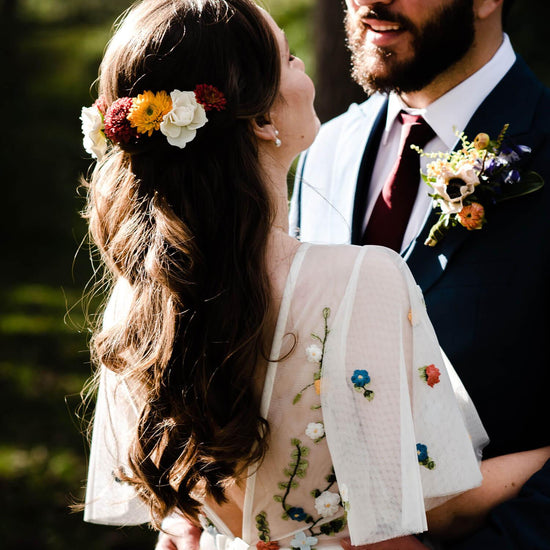A person with a floral crown made of colorful flowers in their hair. Order online for wedding & event flowers from the best florist in Toronto near you.