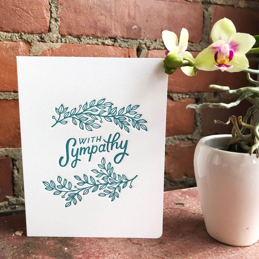
                      
                        A sympathy card with teal lettering and leaf designs on a white background.Order online for event items from the best florist in Toronto near you.
                      
                    