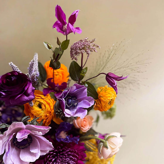 Close-up image of a dynamic bouquet starting with yellows, deepening to lavender and purple, with a touch of acid green for energy. Order online for same-day flower delivery from Toronto's best florist, available near you.