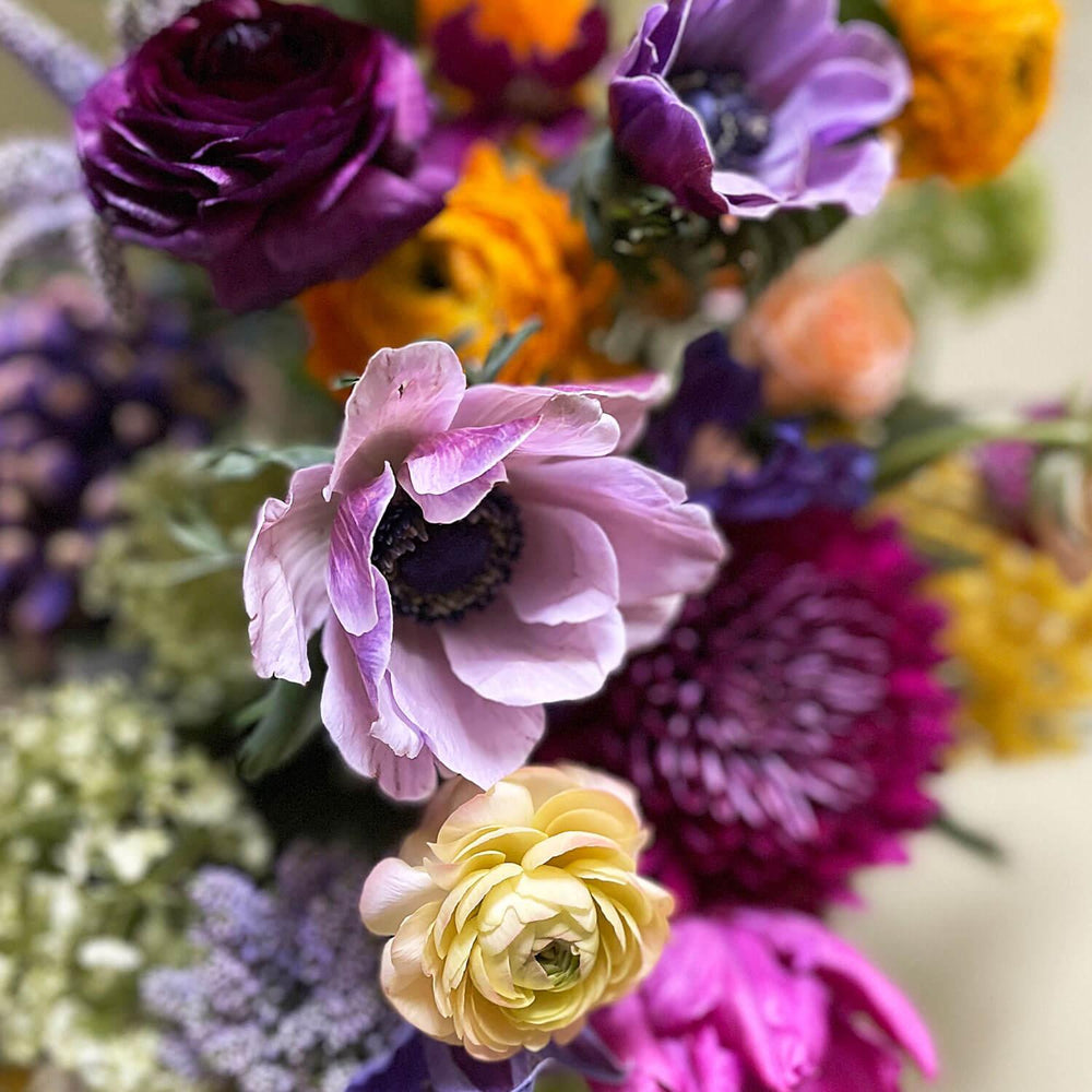 Close-up image of a dynamic bouquet starting with yellows, deepening to lavender and purple, with a touch of acid green for energy. Order online for same-day flower delivery from Toronto's best florist, available near you.