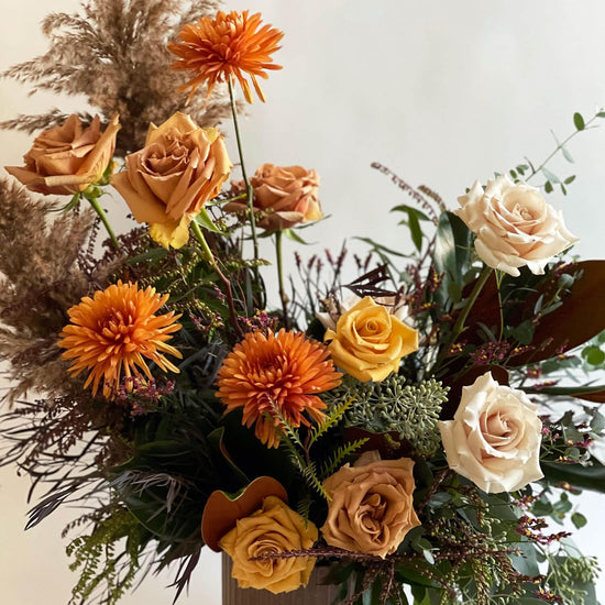 Load image into Gallery viewer, Close-up image of a bouquet featuring flowers in warm earth tones, including mustard yellow, terra cotta, and cayenne, paired with nudes and off-whites. Order online for same-day flower delivery from Toronto&amp;#39;s best florist, available near you.
