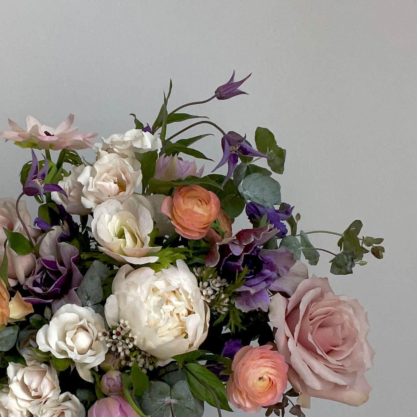 Close-up Image of a bouquet inspired by dusky lilac hues, mostly white with moody lavender, rose, and apricot flowers. A thoughtful and romantic combination. Order online for same-day flower delivery from Toronto's best florist, available near you.