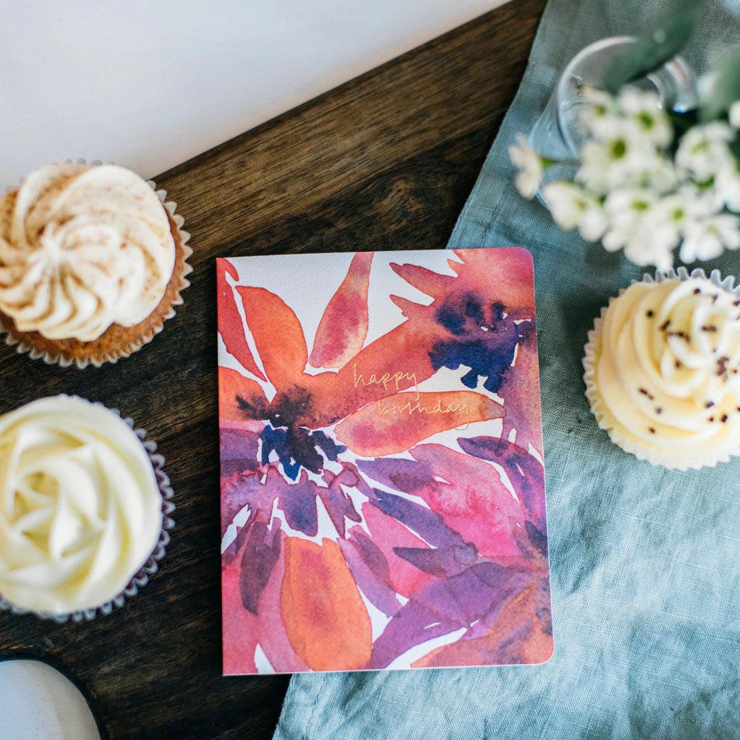 A colorful watercolor painting of flowers on a birthday card with the text ‘happy birthday’ written in elegant cursive.Order online for event items from the best florist in Toronto near you.